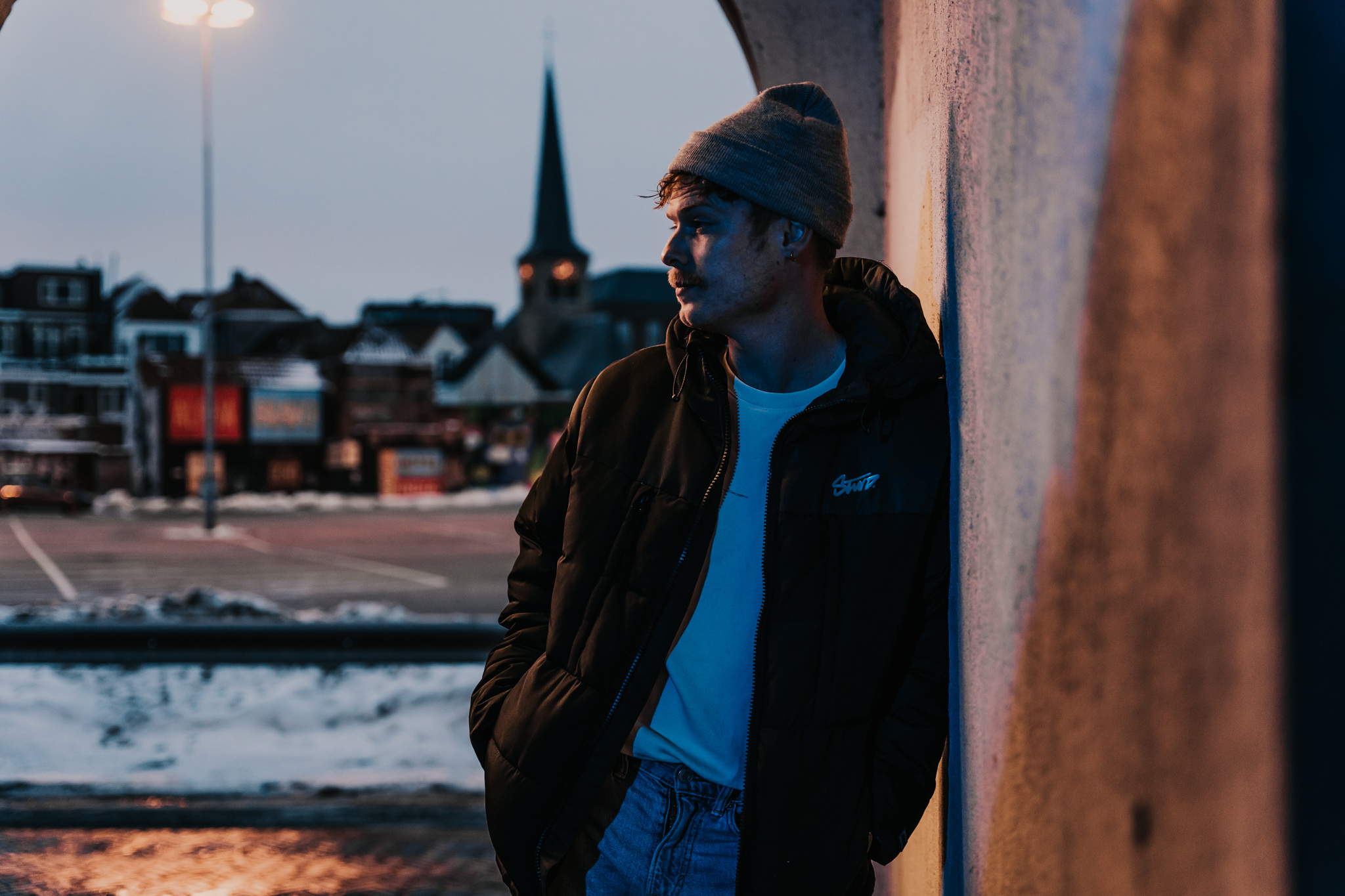 Jongen leunend tegen een muur die iemand nakijkt